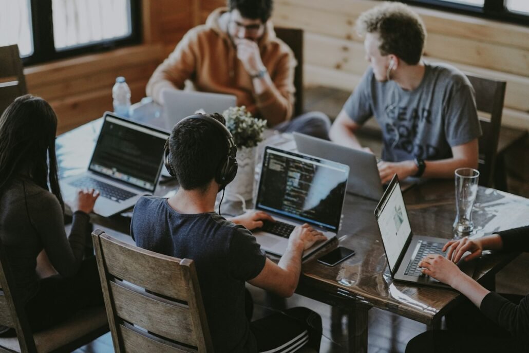 Web design team collaborating around a laptop